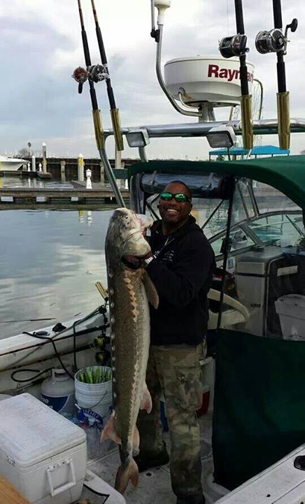 Angler holding a catch below a boat-mounted rod holder array