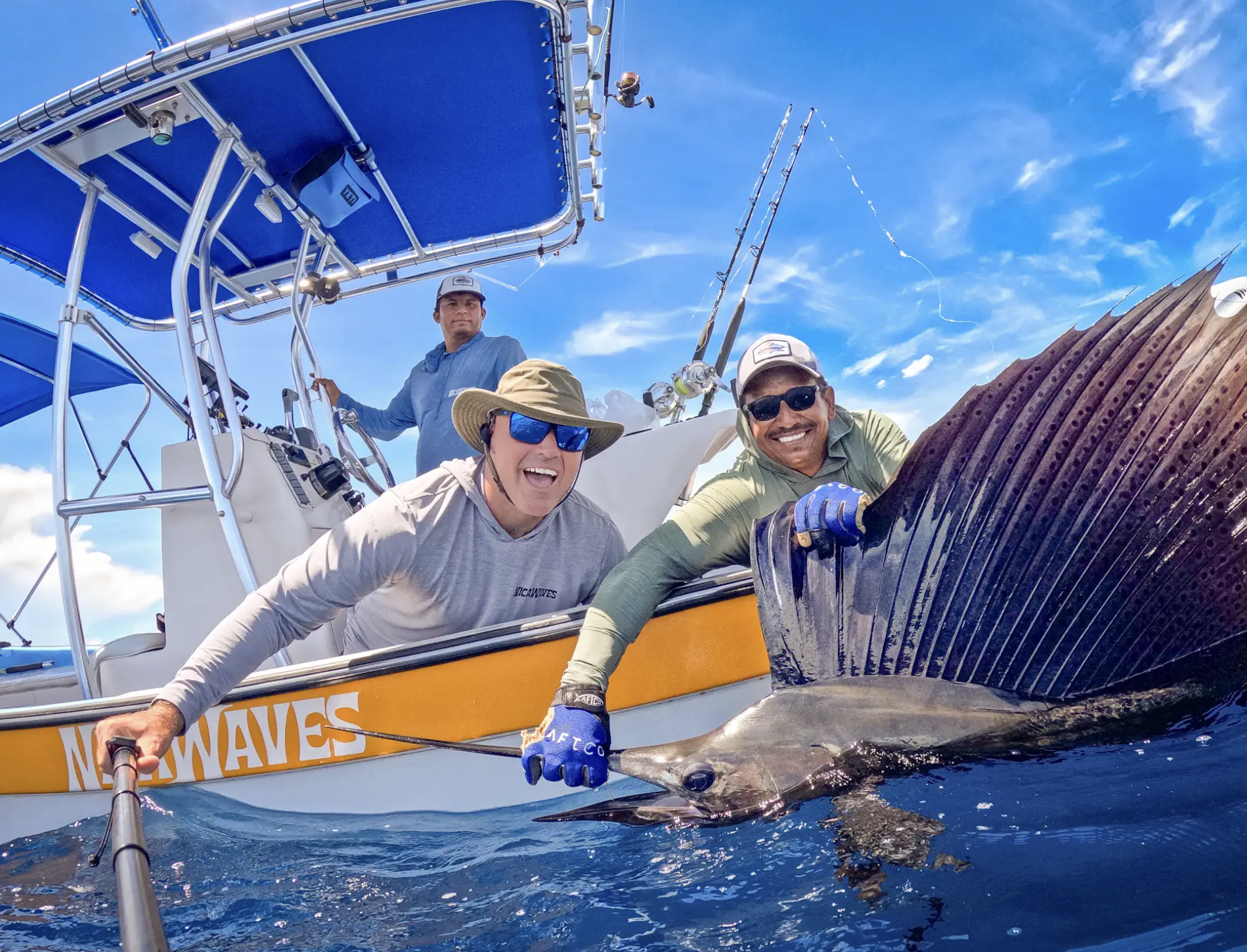Anglers beside a billfish on a boat equipped with a blue Tower in a Box® top and rod holders